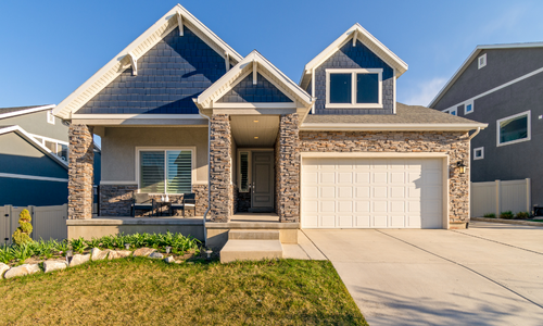 Exterior of small family home with cobblestone accents and a concrete driveway