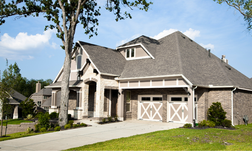 Neutral colored country style home with a concrete driveway