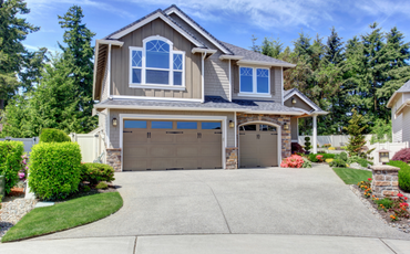 house that is painted brown with white trimming and a concrete driveway