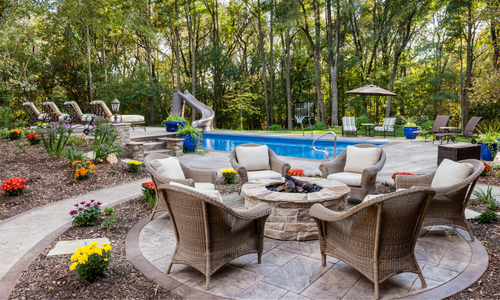 Patio with a fire pit featuring chairs around the pit and elegant stamped concrete flooring with a matching pathway to the left
