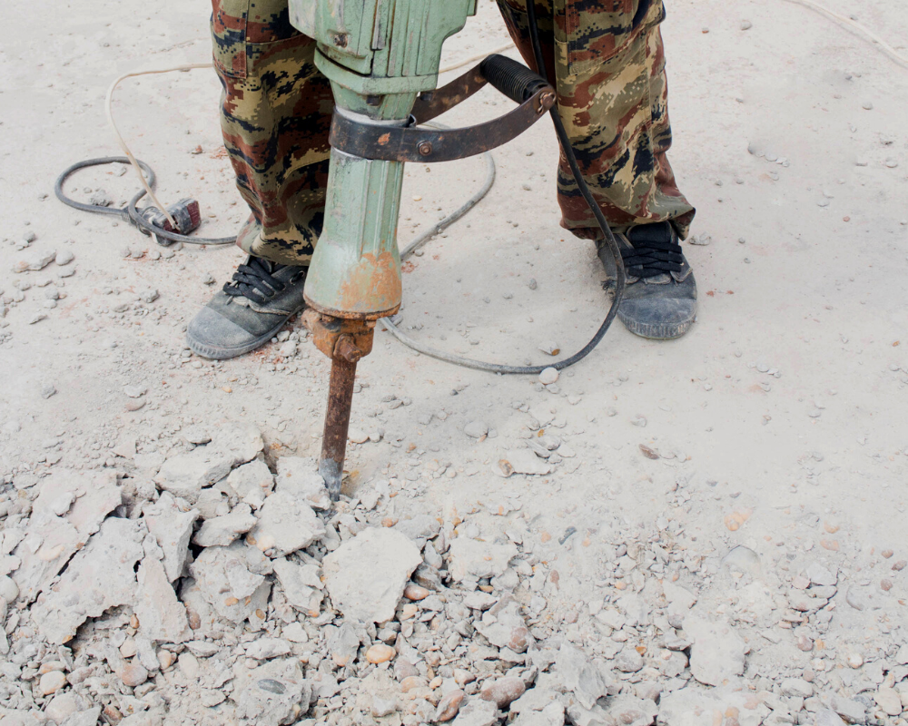 up-close shot of concrete being jackhammered into small pieces before being repaired.