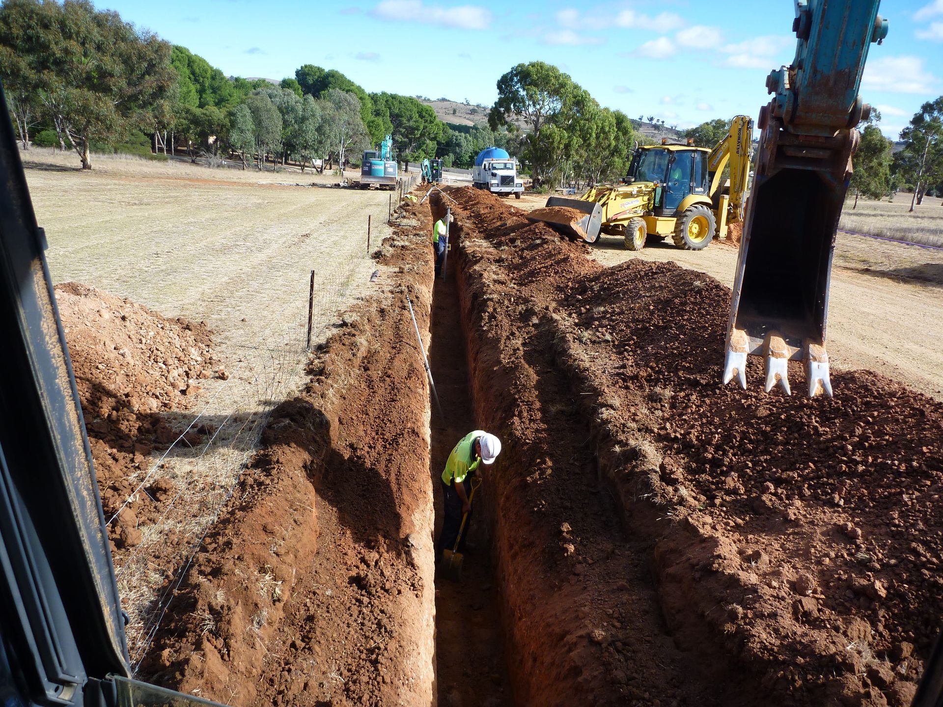 A yellow tractor is digging a trench in the dirt | Murray Bridge, SA | Ridleys SA