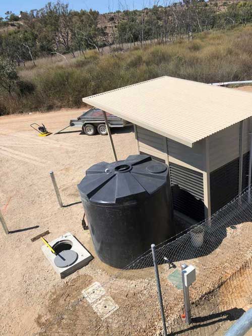 A large black tank is sitting in the middle of a dirt field next to a fence | Murray Bridge, SA | Ridleys, SA 