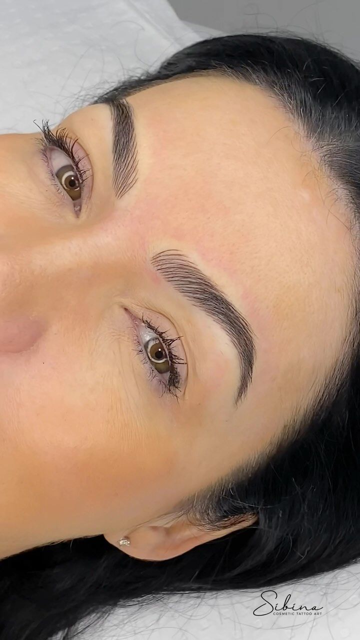 Close-up of a face with defined eyebrows and warm-toned makeup, rotated sideways on a white background