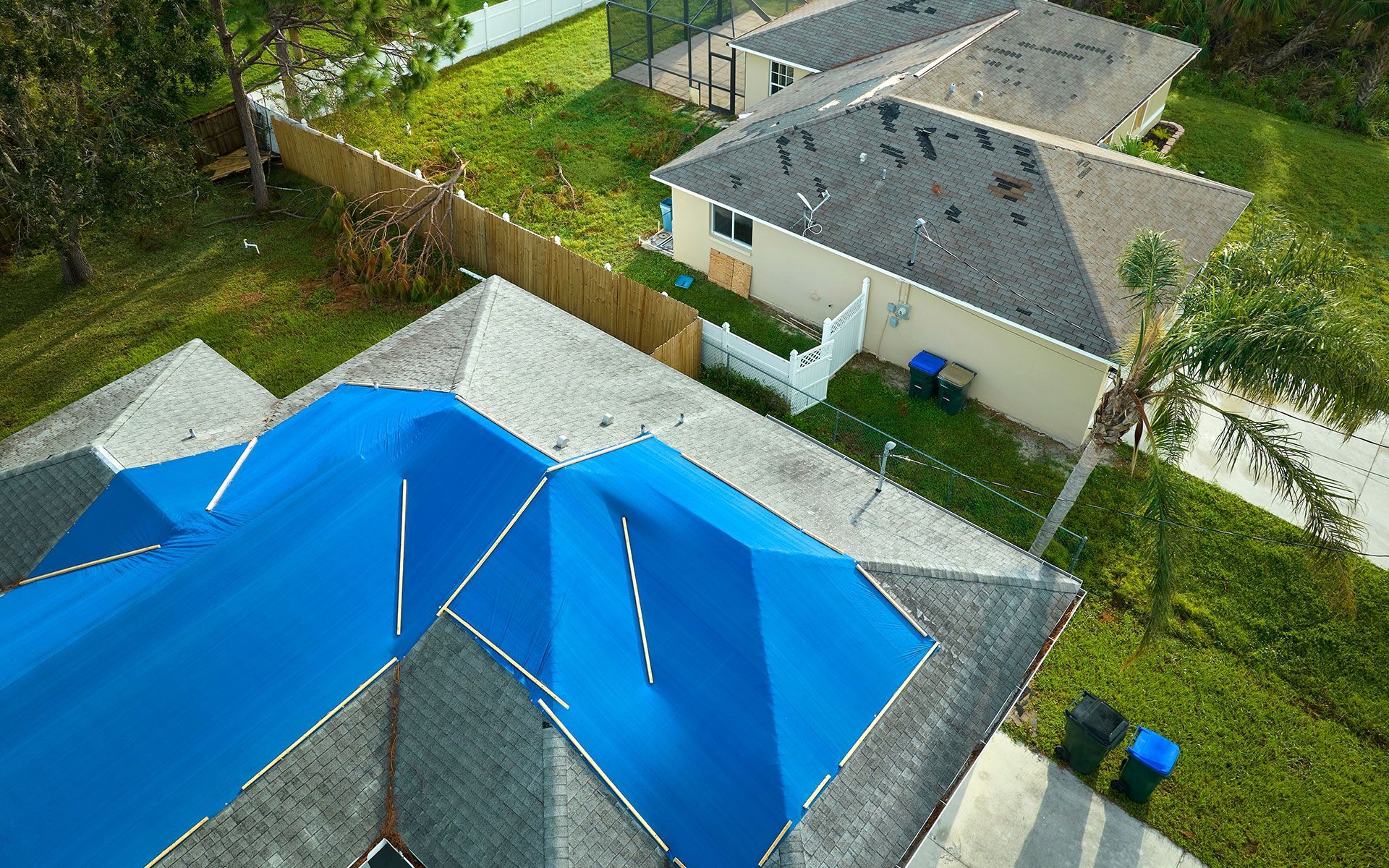 An aerial view of a house with blue umbrellas on the roof.