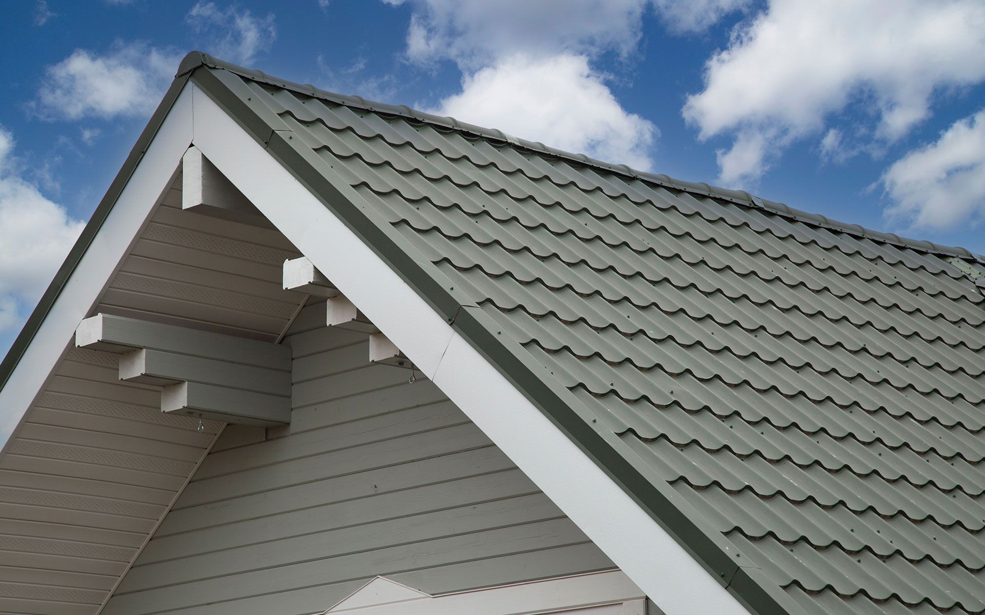 The roof of a house with a blue sky in the background