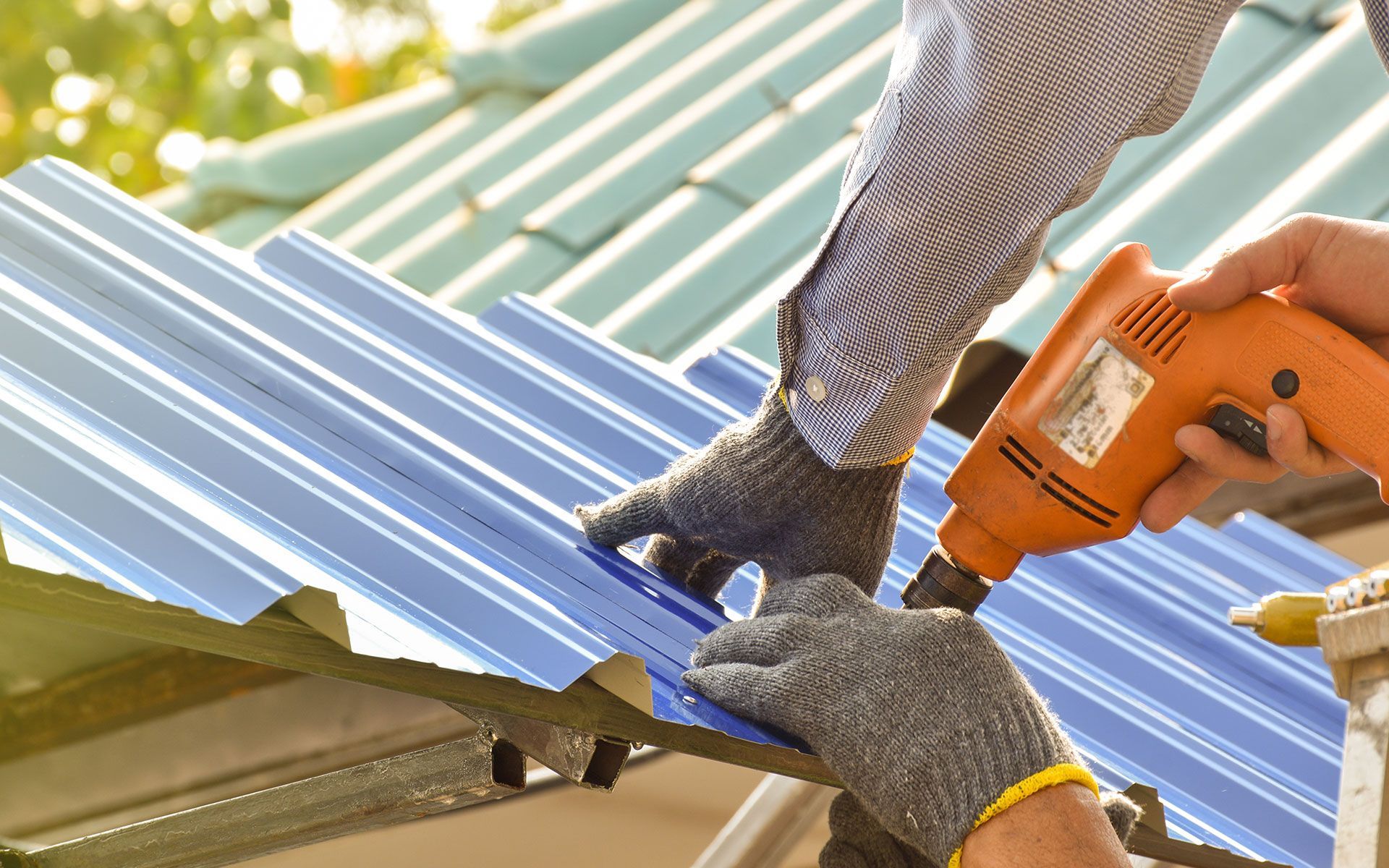 A person is working on a roof with a drill.