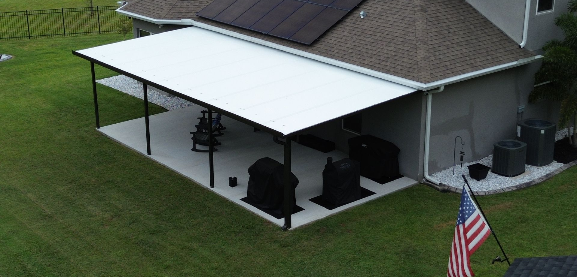 new lanai porch build with bronze aluminum, new concrete, and a white, 3 inch composite insulated roof.