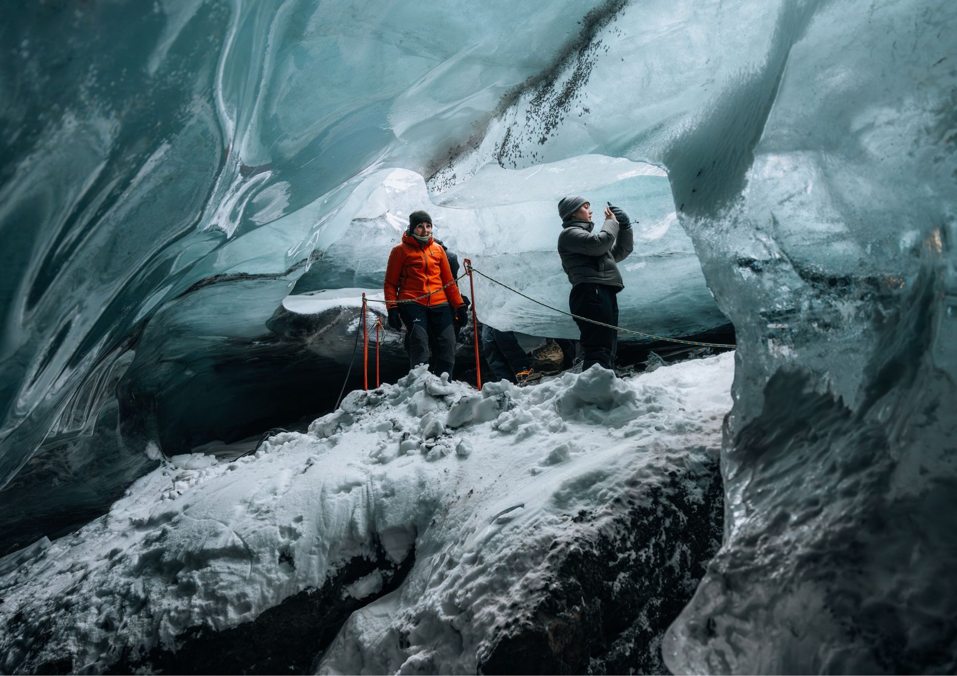 Guests walking through the bright blue natural ice cave on Langjökull glacier