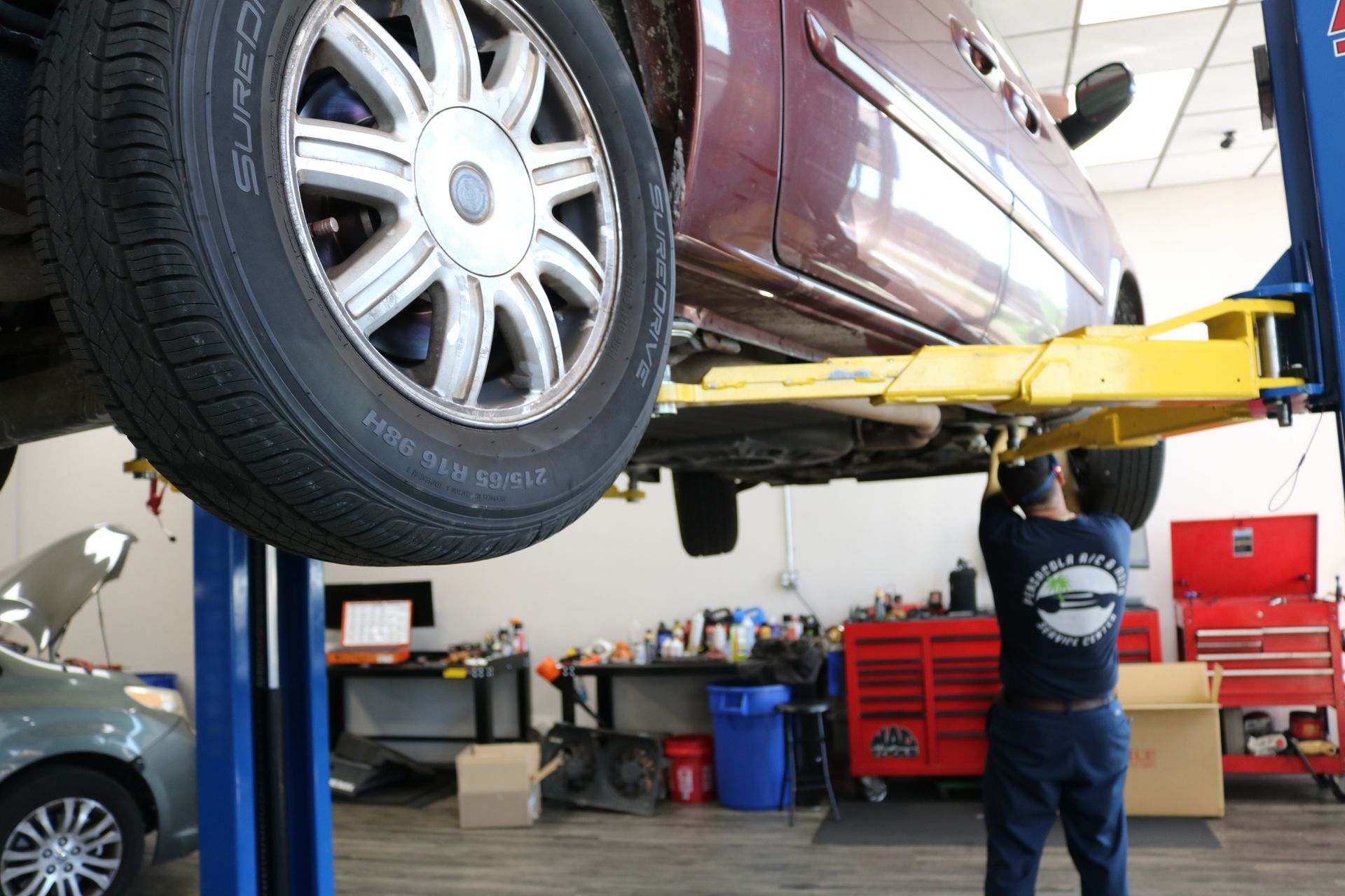 Mechanic Working on Car Under Chassis | Best Mechanic in Pensacola, FL - Pensacola AC & Auto Service Center