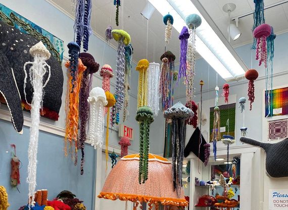 Multicolor handmade yarn jellyfish hanging from the classroom ceiling.