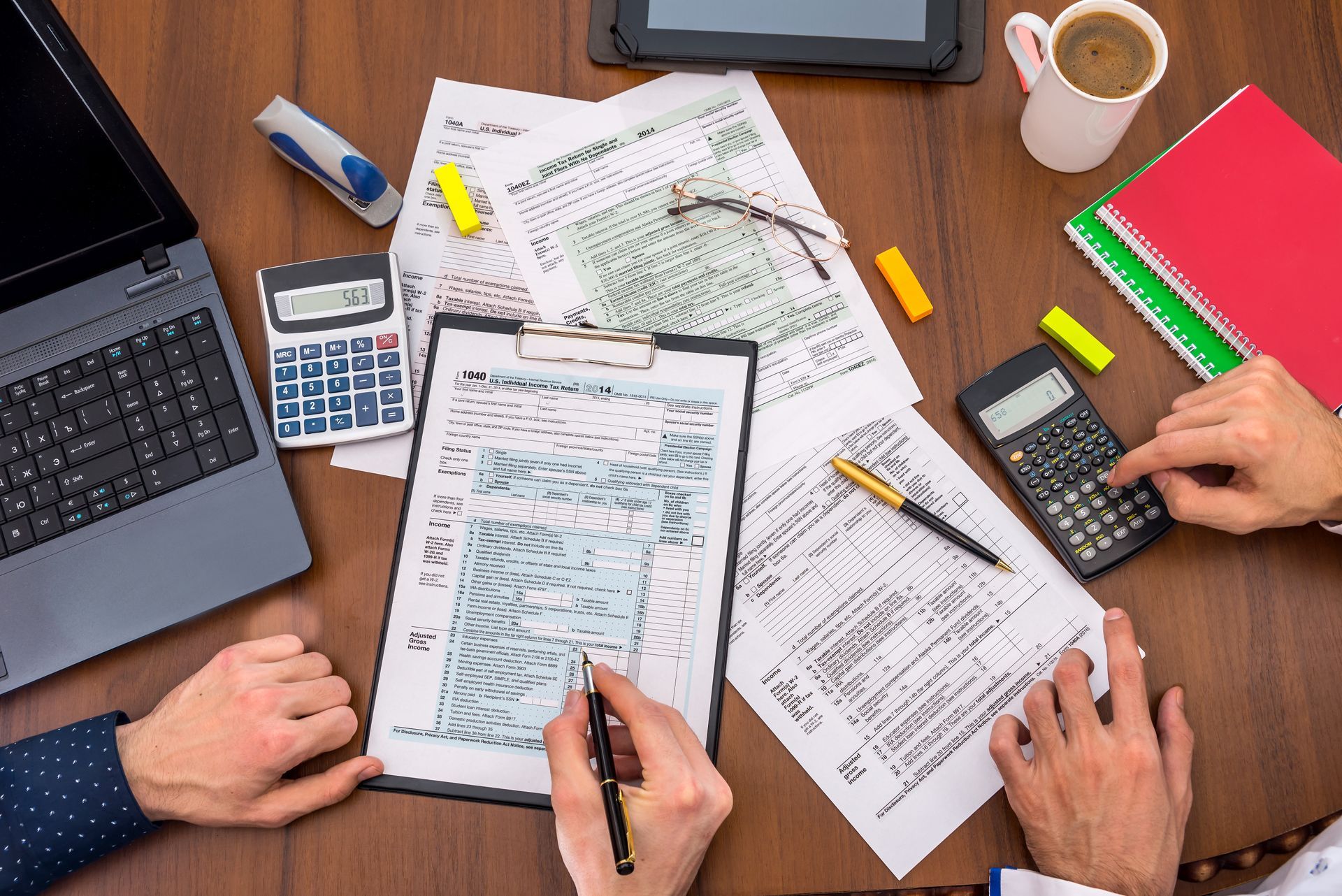 Two people filling tax forms. Two people filling tax forms.