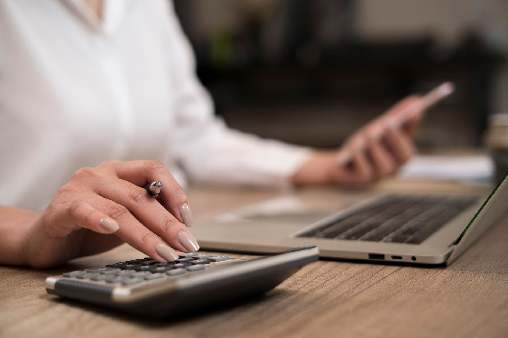 Female accountant uses calculator, showing tax return preparation Finck, Rudnick & Company offers in