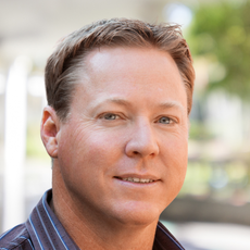 A man in a striped shirt is smiling for the camera