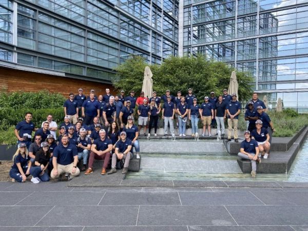 A large group of people are posing for a picture in front of a building.