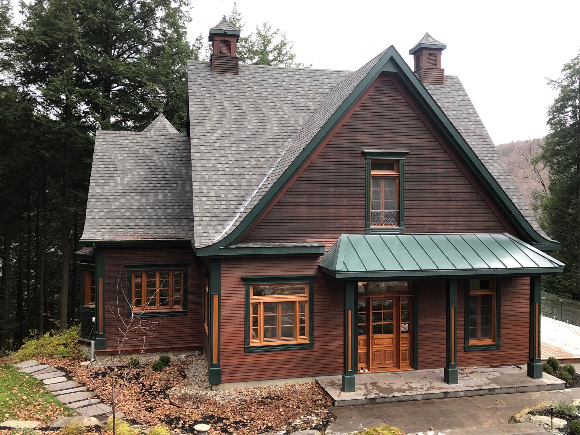 Une grande maison en bois avec un toit vert