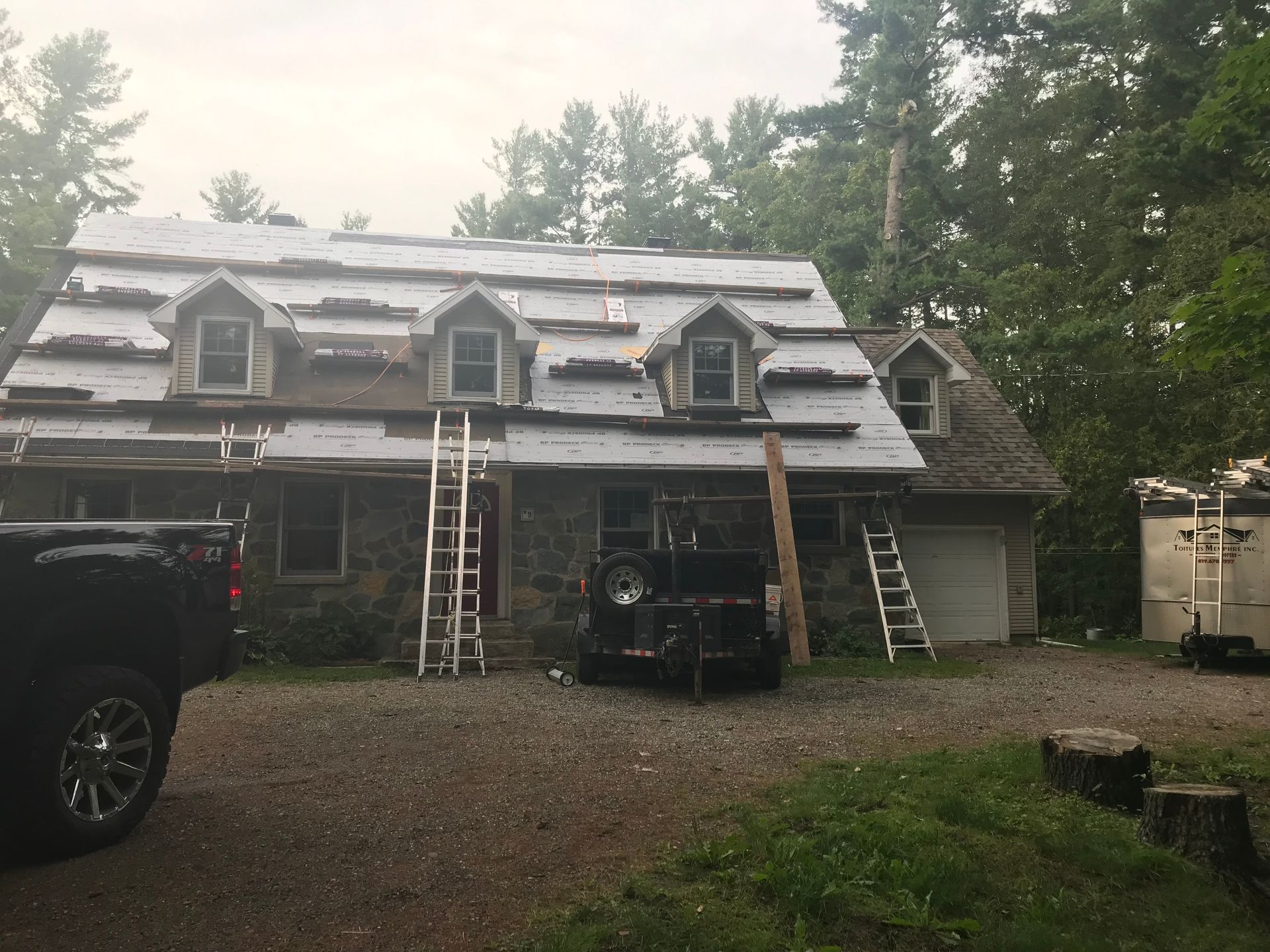 Un camion est garé devant une maison en cours de rénovation.