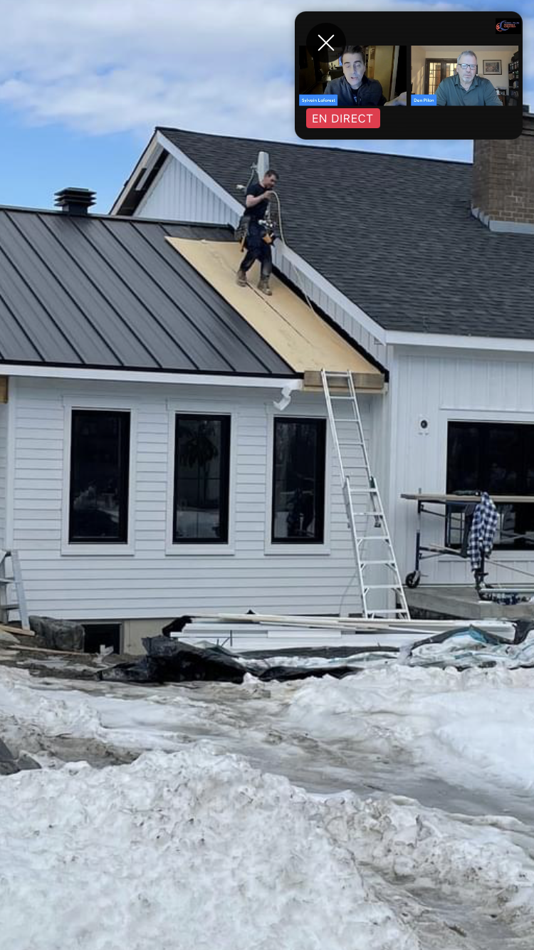 Un homme se tient sur le toit d'une maison.