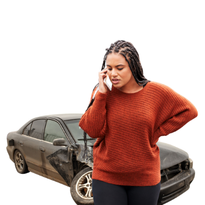 A person with braided hair looks concerned while talking on a phone in front of a heavily damaged sedan.