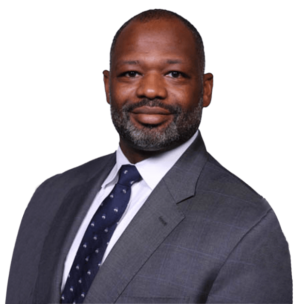 Headshot of Daniel R. Crumby wearing a gray suit, white shirt, and navy blue patterned tie against a white background.