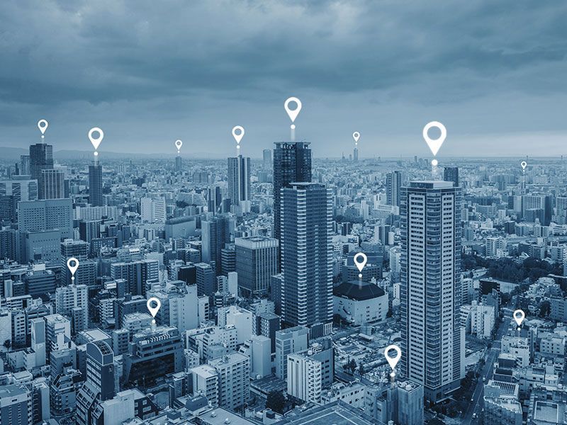 Uma vista aérea de uma cidade com muitos edifícios e marcadores de mapa.