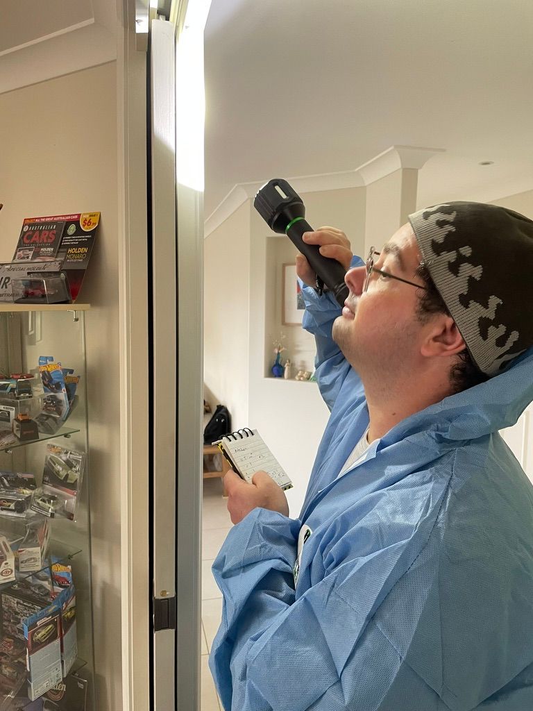 Man Examining an Area Near a Glass Display Case — NatureWise Pest Control In Port Macquarie, NSW