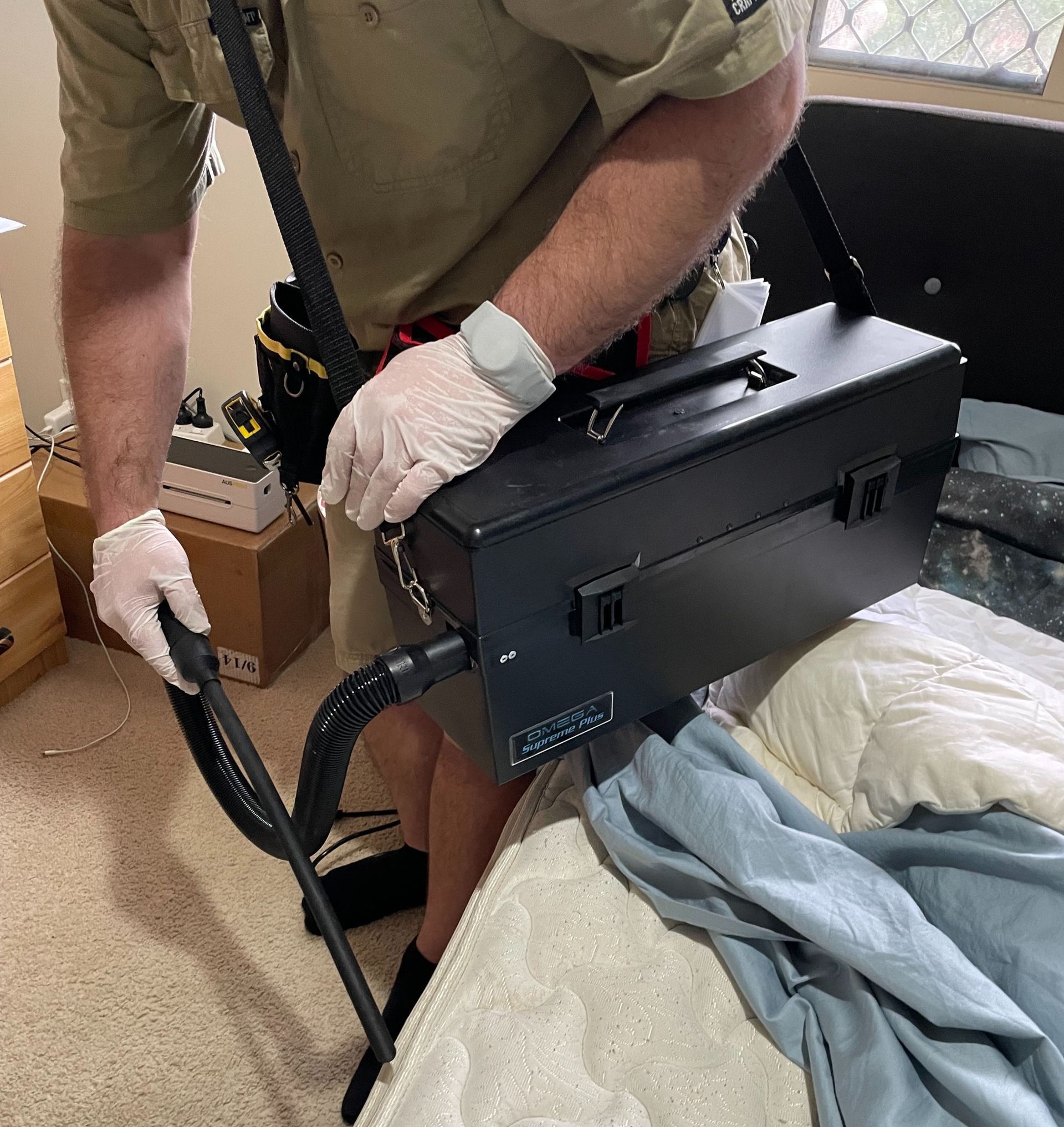 Person in Gloves Uses a Vacuum on a Bed — NatureWise Pest Control In Port Macquarie, NSW