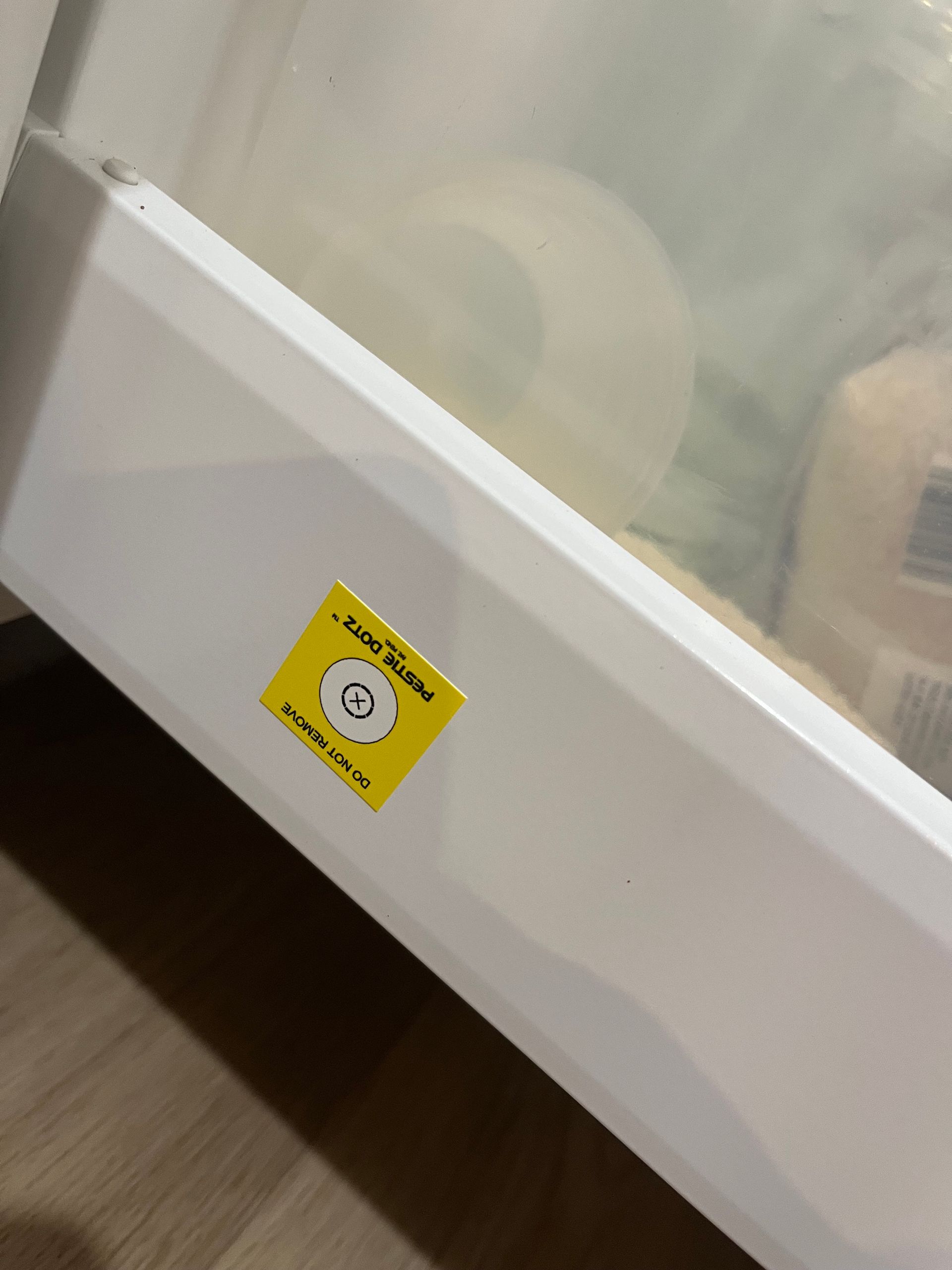 Yellow Warning Sticker on a White Refrigerator Door Near the Bottom — NatureWise Pest Control In Port Macquarie, NSW