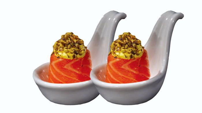 Due pezzi di nigiri al salmone con riso, serviti in ciotole bianche su uno sfondo chiaro