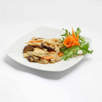 Saltato misto impiattato con verdure e decorato con fiori di carota, su un piatto bianco