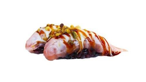Rotolo di sushi guarnito con salsa e condimenti su sfondo bianco