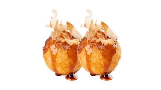 Due pasticcini dorati e fritti, guarniti con cocco grattugiato, su sfondo bianco