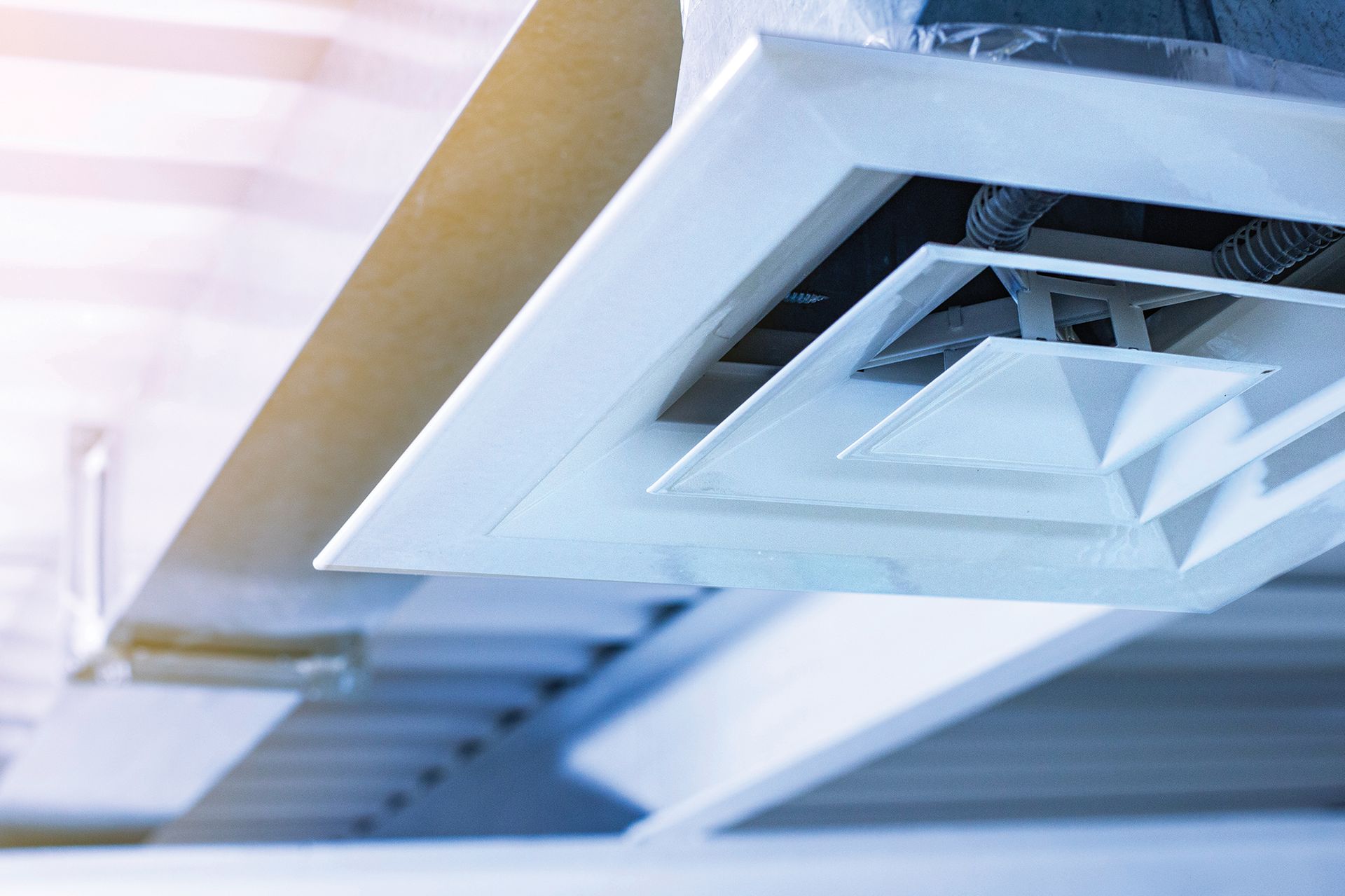 A close up of an air vent on the ceiling of a building.