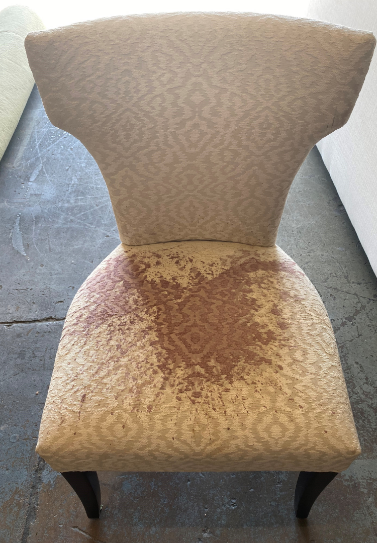 A chair with a pattern on it is sitting on a concrete floor.