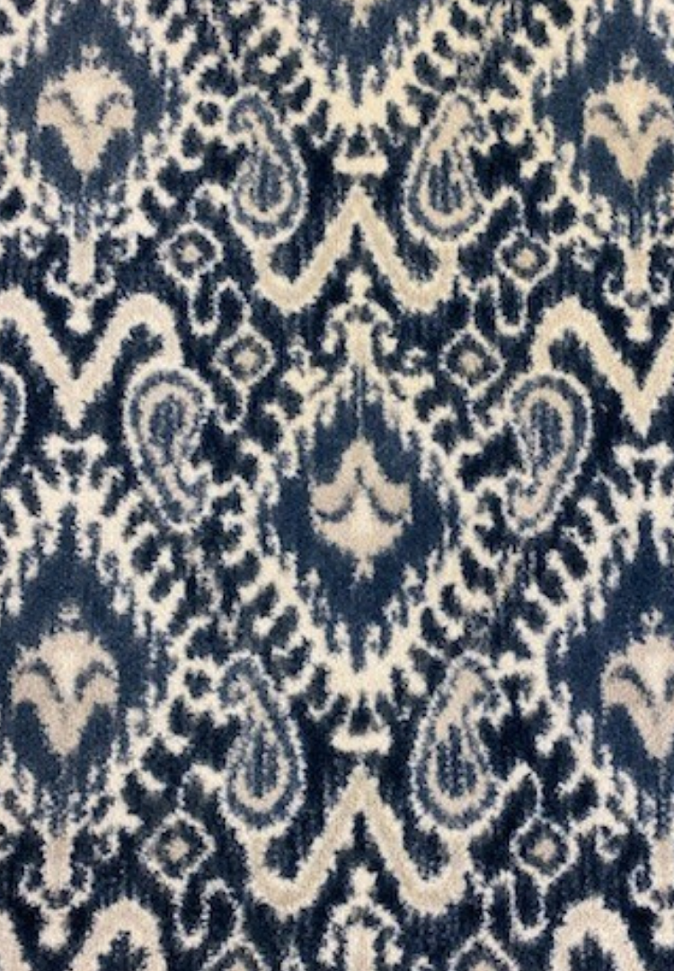 A close up of a blue and white rug with a pattern on it.