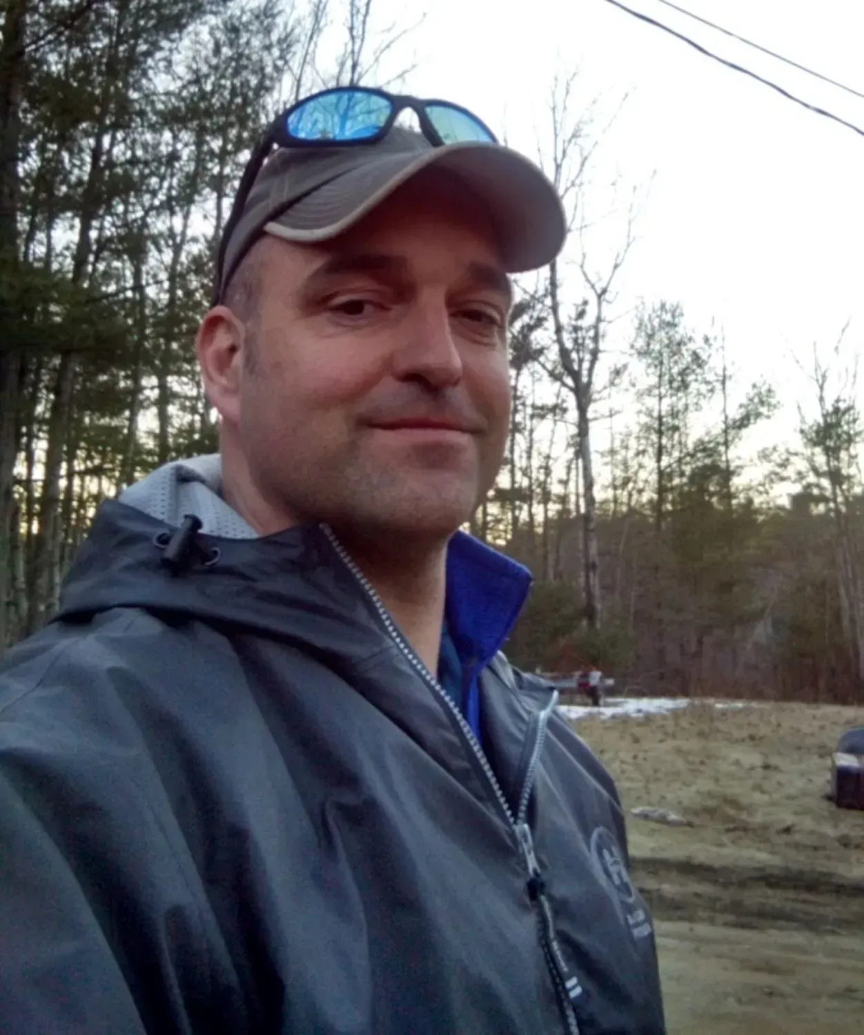 A man wearing a hat and sunglasses takes a selfie