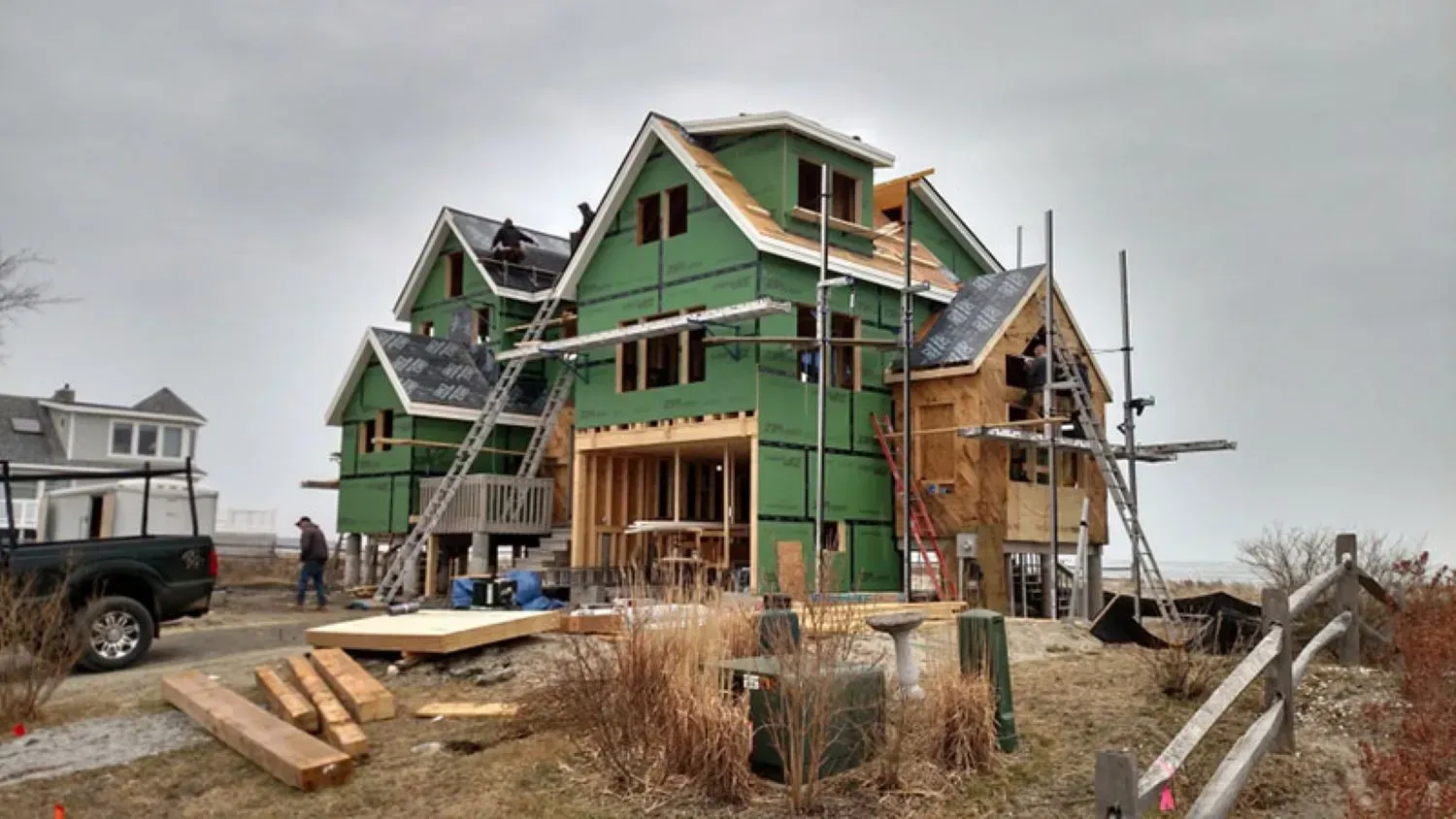 A large house is being built in the middle of a field.