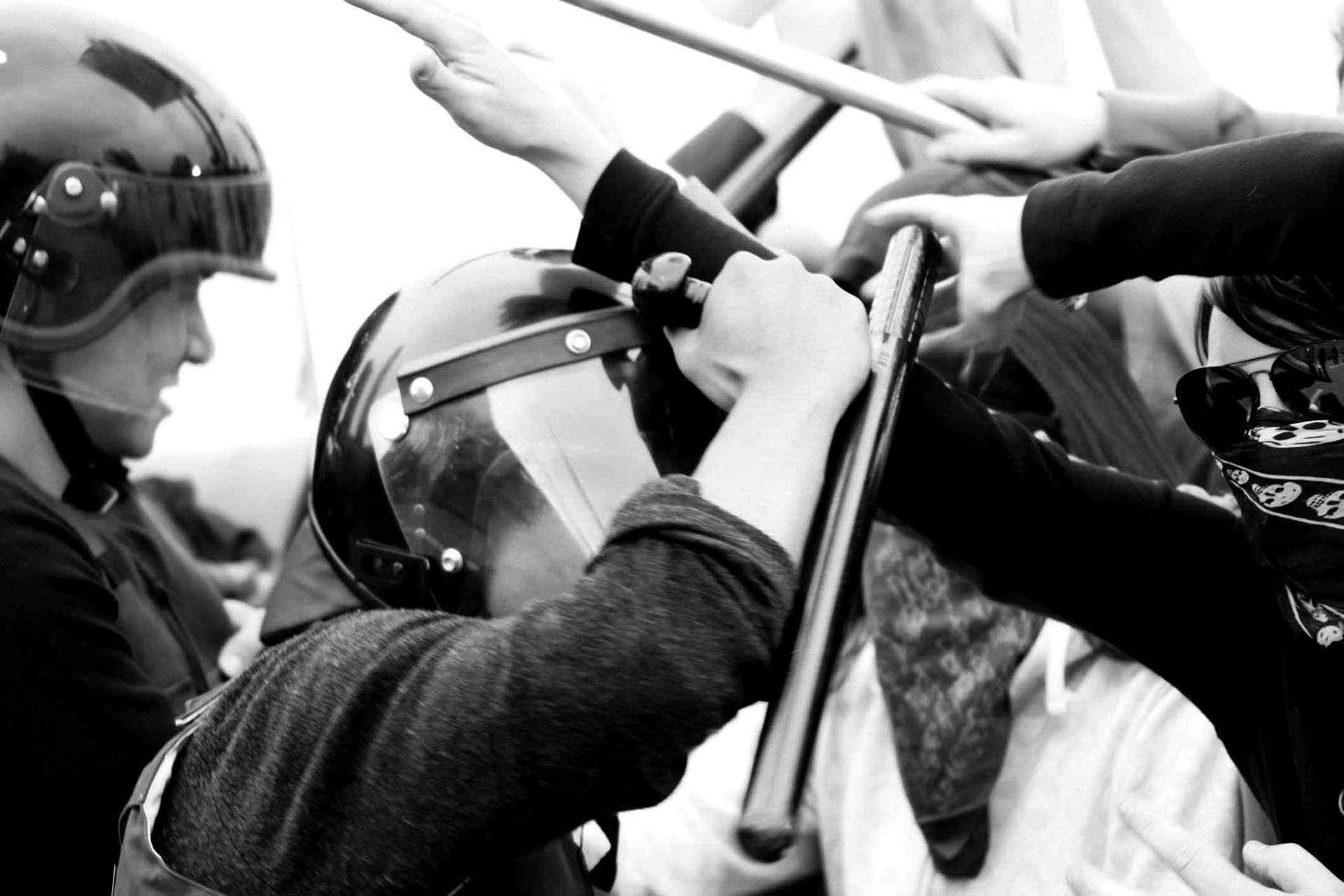 A black and white photo of a man wearing a helmet holding a baton A black and white photo of a man wearing a helmet holding a baton