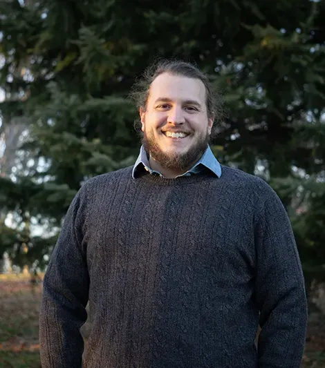 A man in a suit and tie is smiling for the camera.