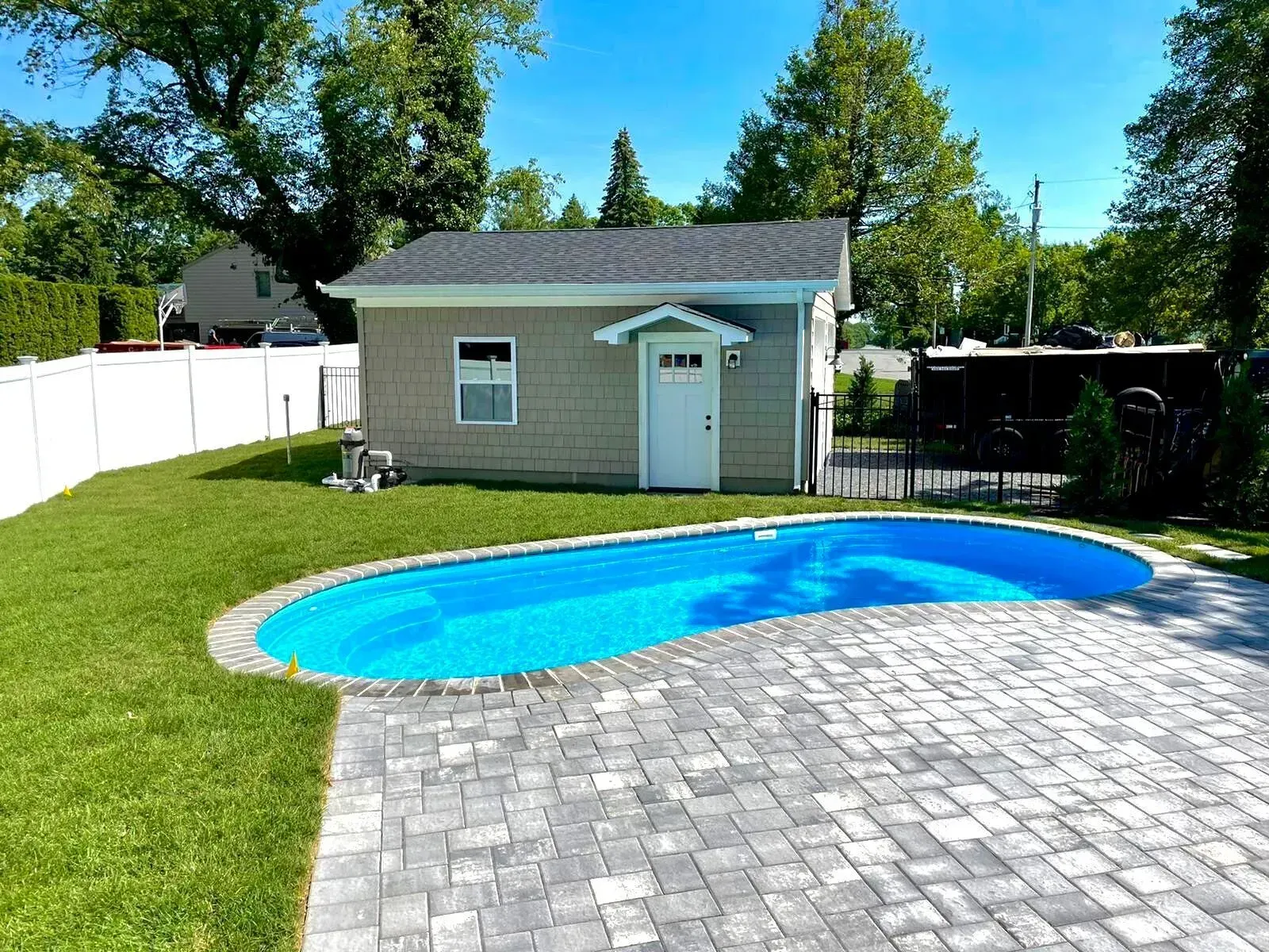 A small house with a swimming pool in front of it.