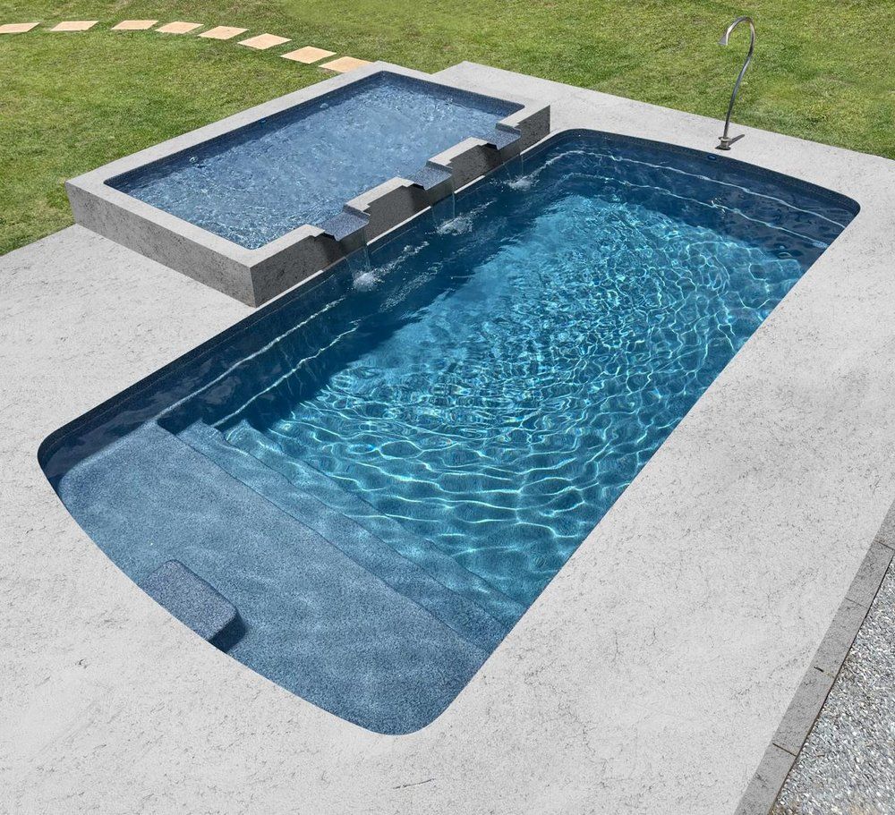 A swimming pool with a waterfall in the backyard
