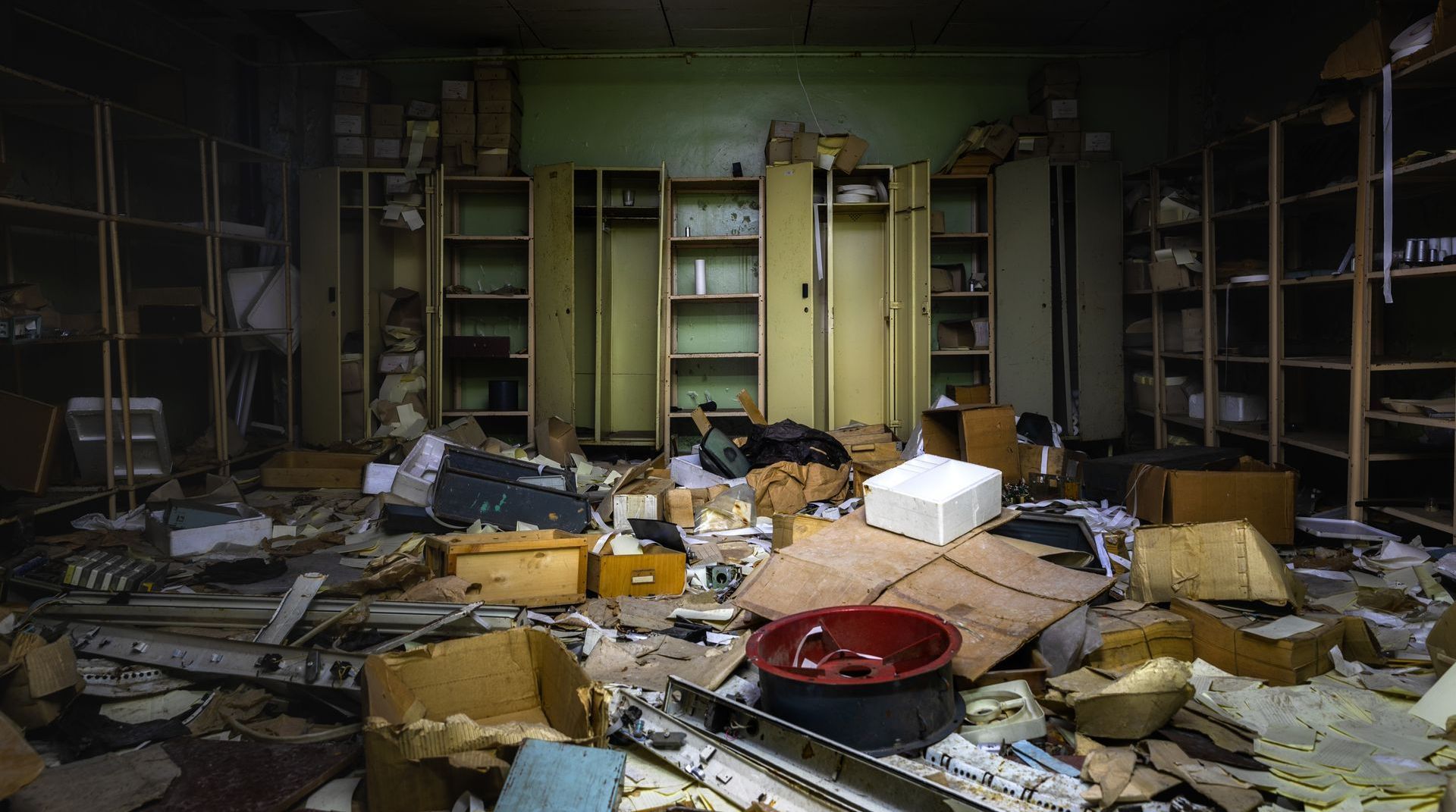 A room with a lot of boxes on the floor and shelves.