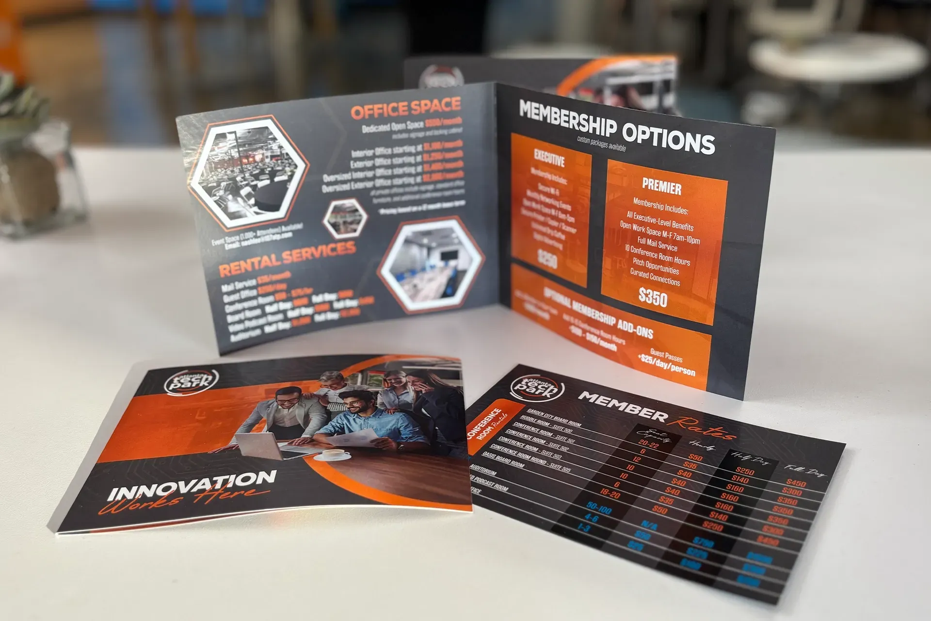 Tri-fold brochure with orange and black tech-themed design on a table