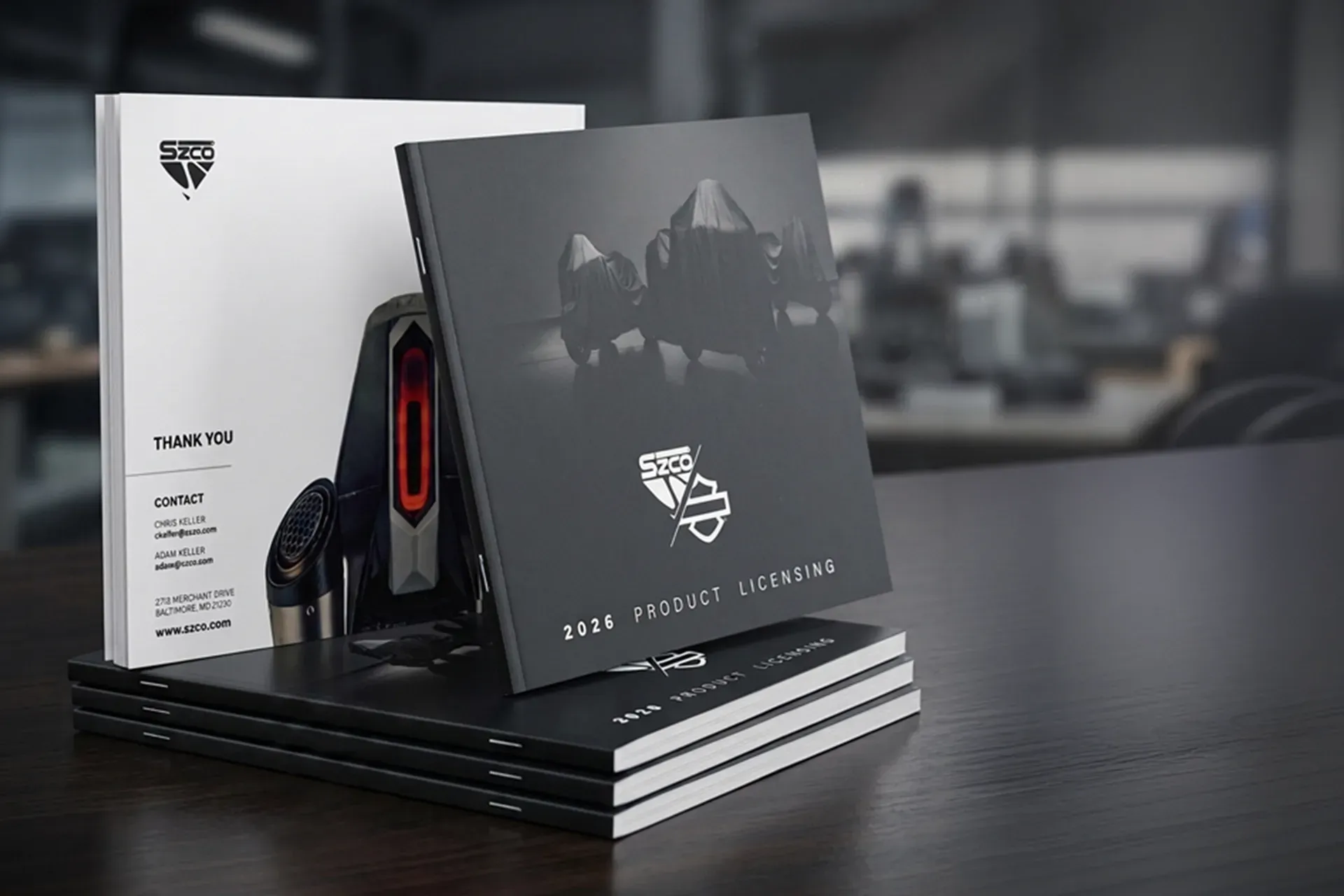 Stack of black booklets with a white booklet on a dark table in a blurred office setting