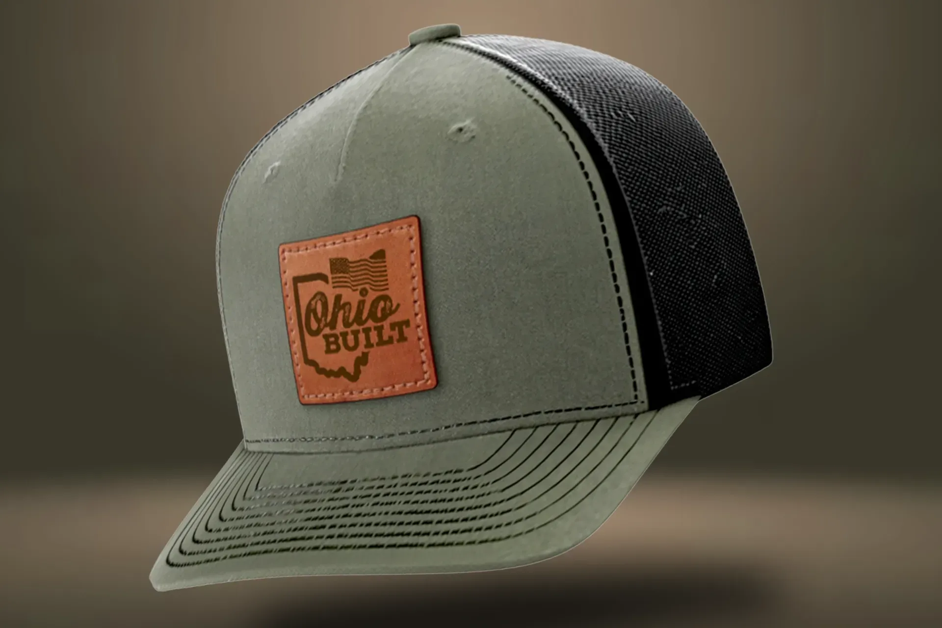 Olive and black mesh trucker cap with a leather patch reading “Ohio Built.”