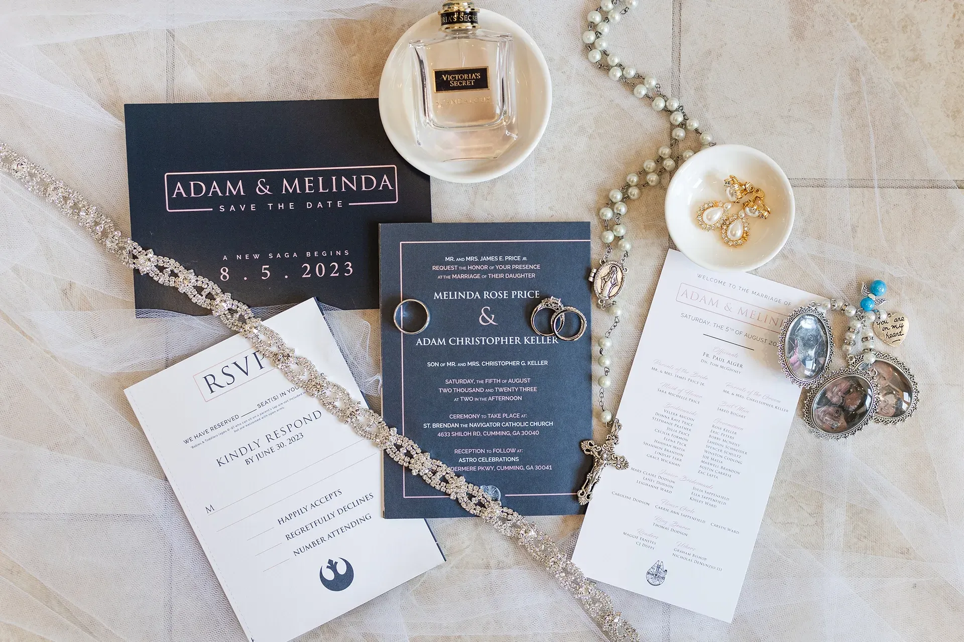 Wedding invitation suite with champagne accents, pearls, and gold details on a lace surface