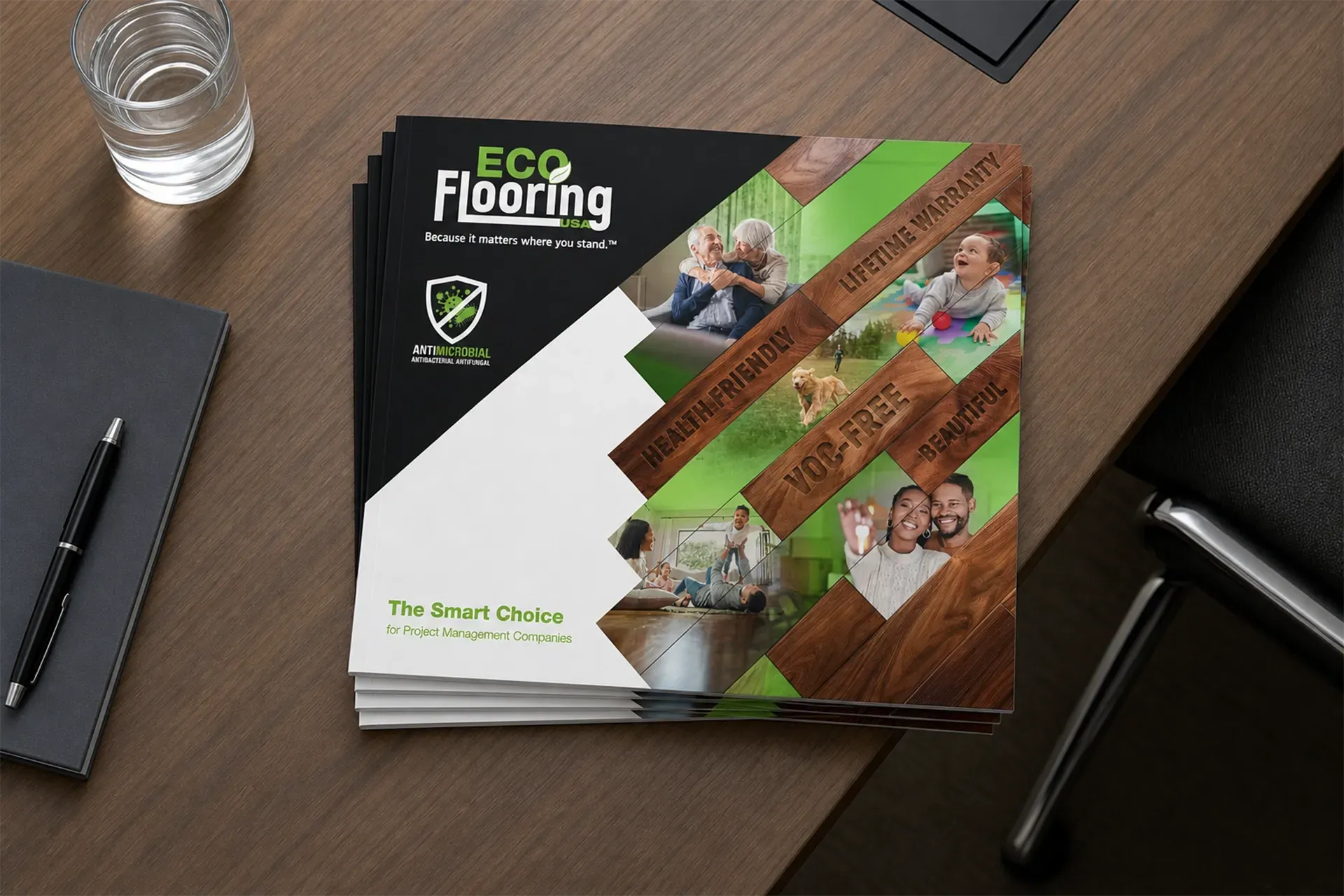 Eco Flooring brochure on a wooden desk beside a pen and glass of water