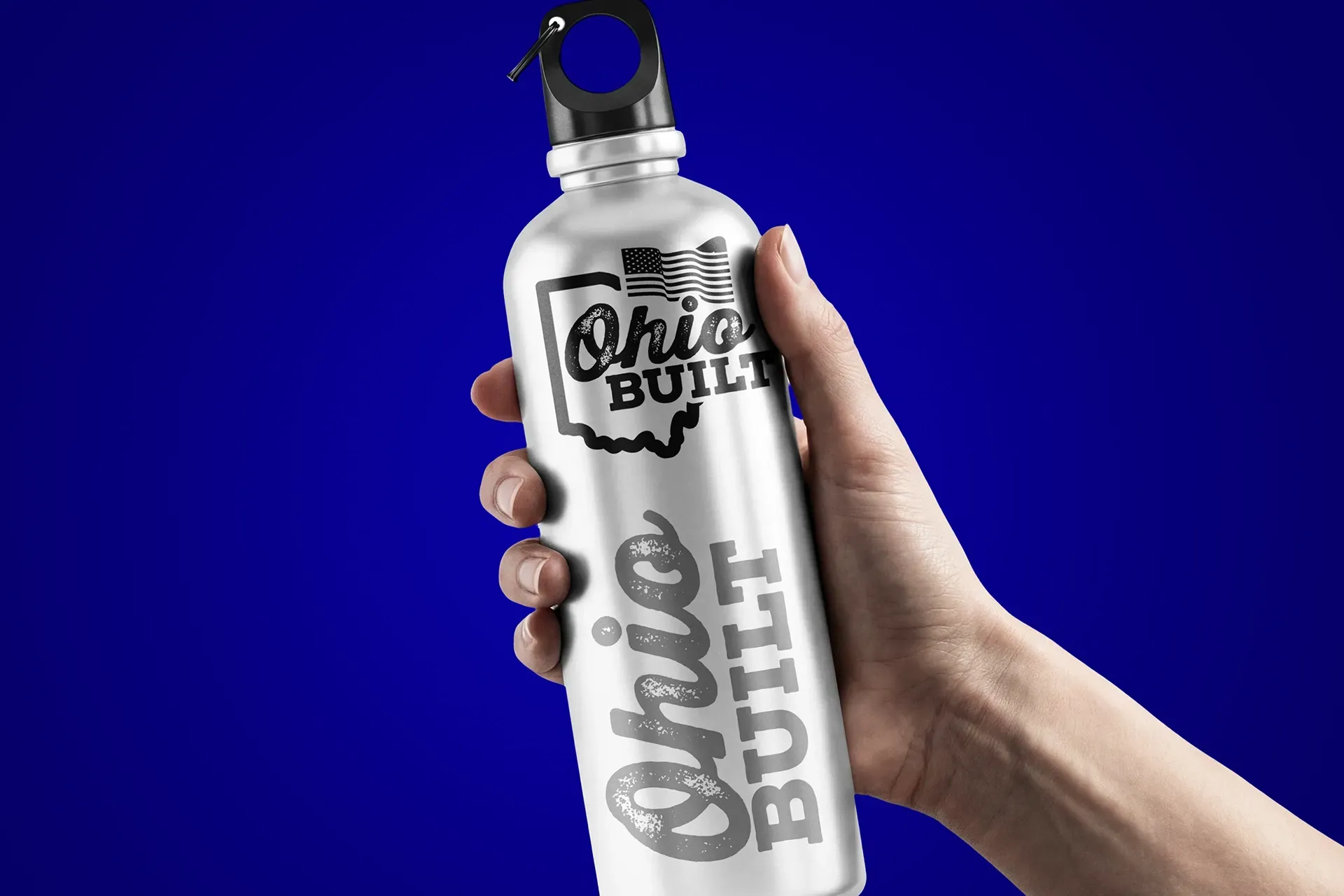 Clear Bob Bullit bottle held by a hand against a blue background