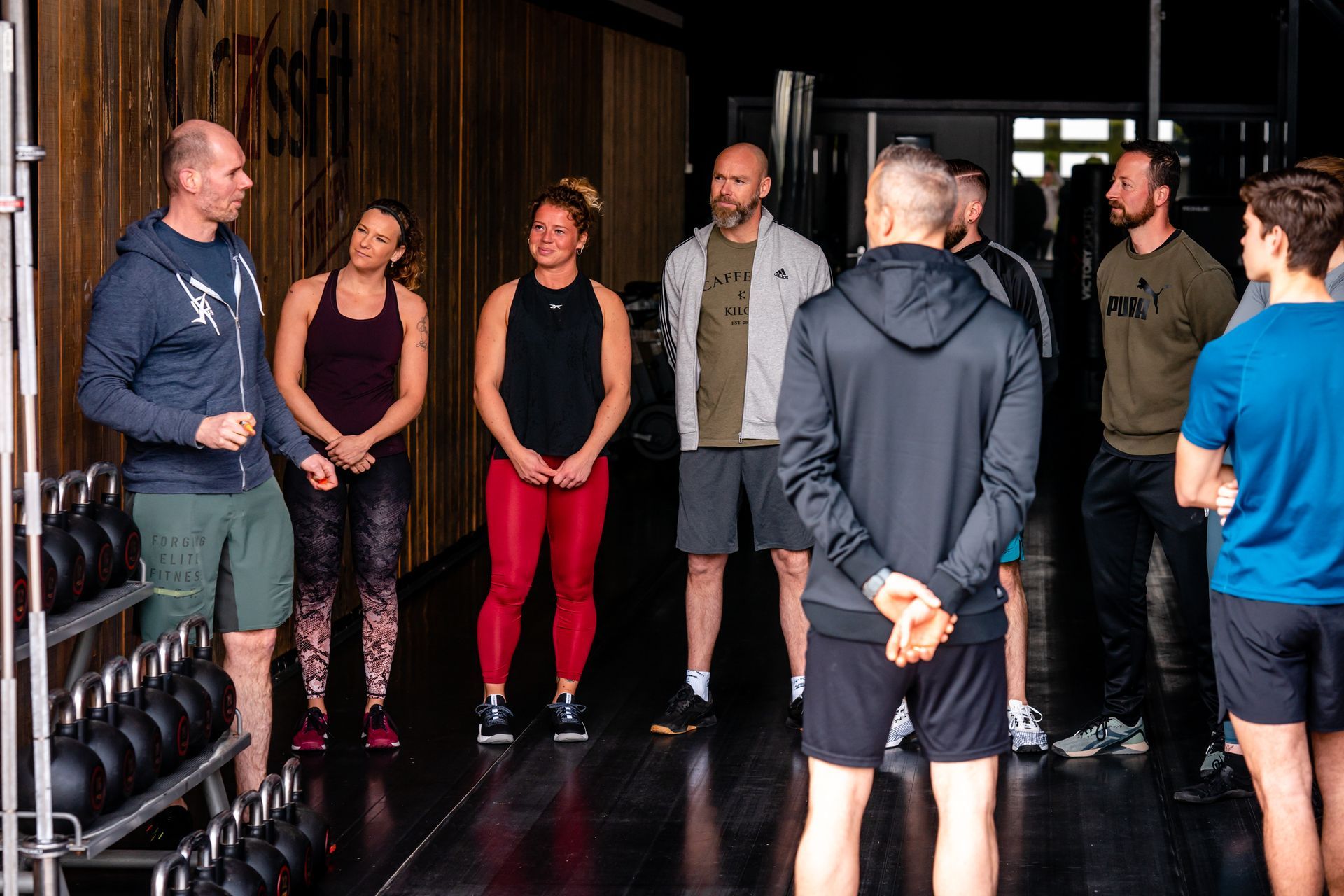 Een groep mensen staat in een gymzaal met elkaar te praten.