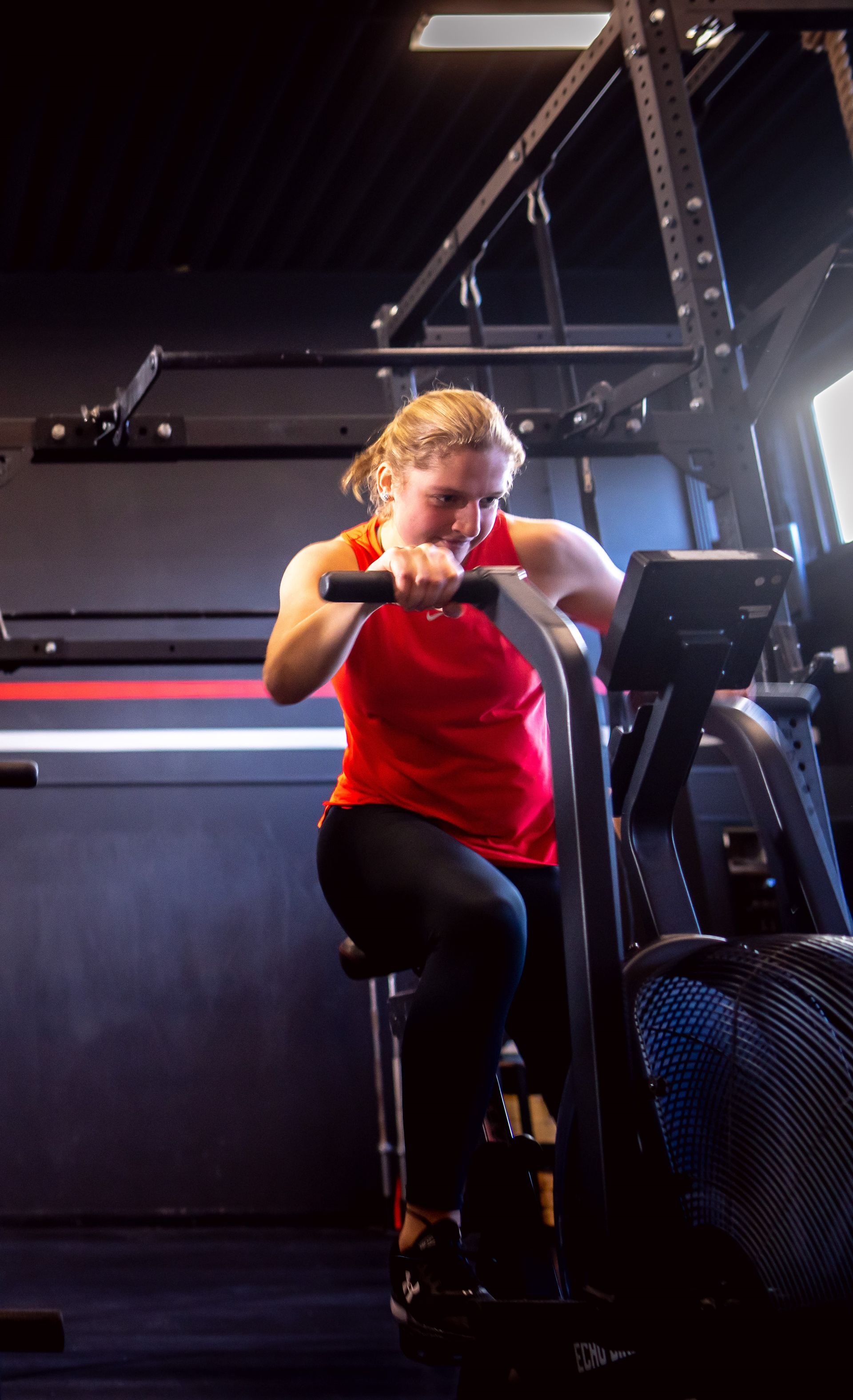 Een vrouw fietst op een hometrainer in een sportschool.
